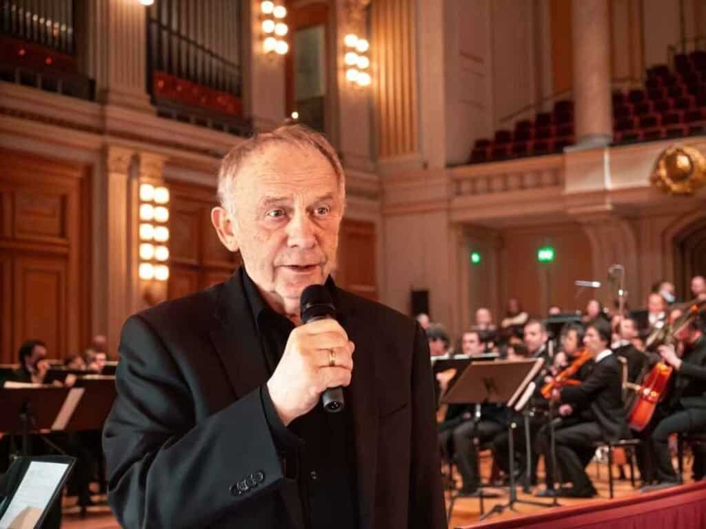 Kunstner holder tale under kirkekonsert i Fosen med orkester og kor.