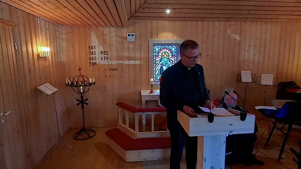 Mann ved talerstol under kirkekonsert i Fosen, innendørs.